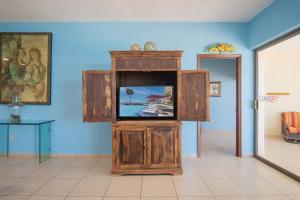 a tv in a wooden cabinet in a room at Happy-N-The-Sun 2 BR Oceanfront in Puerto Peñasco