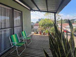 Dos sillas en una terraza con vista a un tren. en El Portal, en Posadas