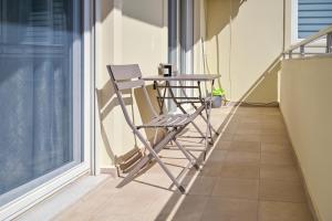 a chair sitting next to a table on a balcony at Stayinn Apartments in Alexandroupoli