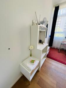 ハンブルクにあるRuhiges Zimmer auf St Pauliの白いキャビネットとテーブルが備わる客室です。