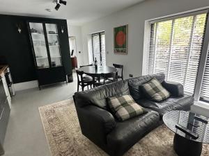 a living room with a leather couch and a table at Collective Yard in Braunton