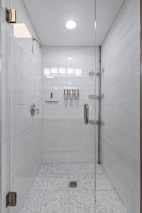 a bathroom with a shower with a glass door at Uptown Elegant Escape | JZ Vacation Rentals in Tower Grove