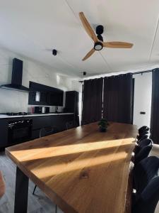 ein Holztisch in einer Küche mit einem Deckenventilator in der Unterkunft Villas de lujo con Chimenea y Vistas Panorámicas a la Sierra de Cazorla in Pozo Alcón