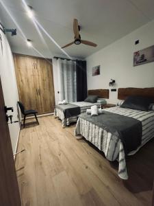 ein Schlafzimmer mit zwei Betten und einem Deckenventilator in der Unterkunft Villas de lujo con Chimenea y Vistas Panorámicas a la Sierra de Cazorla in Pozo Alcón