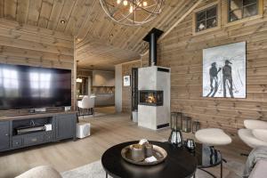 a living room with a television and a fireplace at Trysilfjell 2053 by Vacation Trysil in Trysil