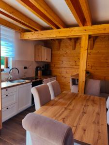 Una cocina con una mesa y sillas de madera en una habitación. en Wood Fairy 2, en Korenica