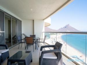 a balcony with chairs and tables and a view of the beach at Playa Blanca Premier Unit 1302 in San Carlos