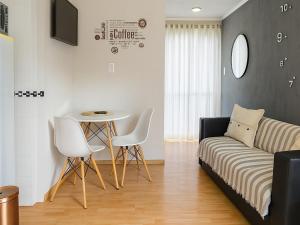 een woonkamer met een bank, een tafel en stoelen bij Posada El Alamo Mendoza in Mendoza