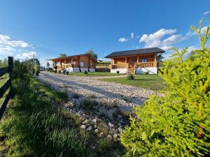 ein Haus mit einer Schotterstraße vor dem Haus in der Unterkunft Sub Stele Chalets in Holbav