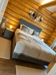 ein Bett in einem Zimmer mit einer Holzwand in der Unterkunft Sub Stele Chalets in Holbav