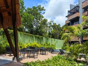 a patio with tables and chairs next to a building at Paramar Black Condominio en Tulum in Tulum