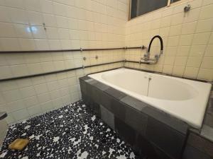una vasca da bagno in un bagno con il pavimento rotto di 海と西一棟貸し宿 a Saitsuno