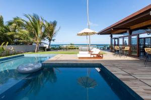 a swimming pool with a view of the ocean at Pousada de Charme Refugio da Villa - Pé na Areia in Porto De Galinhas