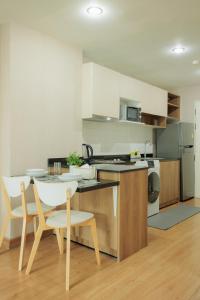 a kitchen with a table and two chairs and a table at Stay Classy Heart Of Nimman in Chiang Mai