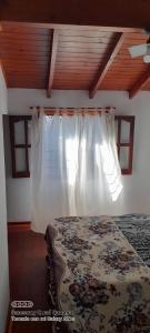 1 dormitorio con 1 cama con cortina blanca en Ensueños del mar, en Las Toninas