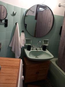 a bathroom with a sink and a mirror and a tub at Elmar House in Paralion astros