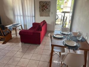 Una sala de estar con un sofá rojo y una mesa. en El Portal, en Posadas