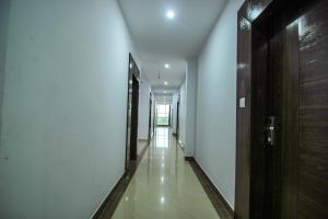 a hallway with white walls and a wooden door at Hotel O Gratos Inn in Bheta