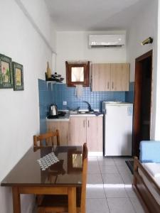 a small kitchen with a table and a refrigerator at Avra Ηouse in Kriopigi