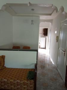 una camera da letto con un letto e un corridoio con un frigorifero di Appart centre a Larache