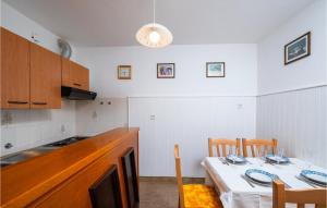 una cocina con mesa y 2 sillas y una cocina con mesa y sillas. en Lovely Apartment In Rabac With Wi-Fi, en Rabac