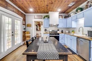 a kitchen with blue cabinets and a wooden ceiling at 1925 Craftsman Bungalow - 1 Mi to Dtwn Waxahachie! in Waxahachie