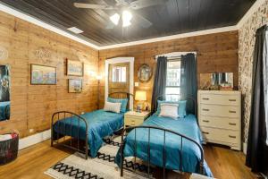 two beds in a room with wooden walls at 1925 Craftsman Bungalow - 1 Mi to Dtwn Waxahachie! in Waxahachie