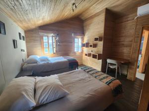 a bedroom with two beds and a desk in it at Palafito Melí Naturaleza y Tradición in Castro