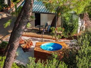 a hot tub in a yard next to a tree at Waterman Beach Village in Supetar