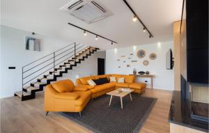 Il comprend un salon doté d'un mobilier orange et d'un escalier. dans l'établissement Stunning Home In Nedescina With Wifi, à Nedeščina