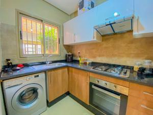 eine Küche mit Waschmaschine in der Unterkunft Luxury Apartment in Prestigia Marrakech in Marrakesch