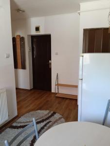 a room with a white refrigerator and a door at Spital studio Mureșului in Târgu-Mureş +3 photos