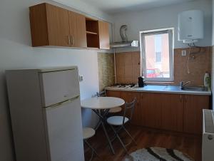 a small kitchen with a white refrigerator and a table at Spital studio Mureșului in Târgu-Mureş