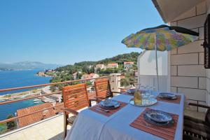 una mesa con sombrilla en el balcón en South Island Apartments en Korčula