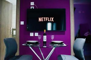 a purple wall with a table with a bottle of wine at SkiathitissasMaison in Skiathos