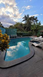 ヴィラ・ヴェーリャにあるCasa Clorophila, suíte com varanda para 4 pessoasの2つの芝生の椅子が横に置かれたプール