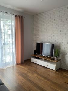 salon z telewizorem z płaskim ekranem na szafce w obiekcie Apartament Miłosz w mieście Ełk