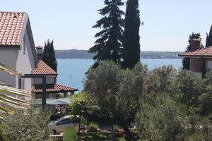 vistas al agua desde un edificio con árboles en B&B Family Skvor, en Portorož