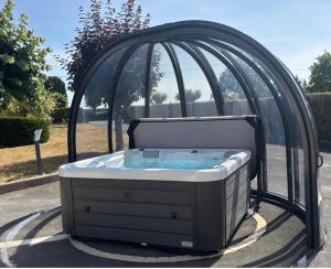a hot tub in a gazebo at Au Gré des Souvenirs, gite 4 à 10 pers, clim, jacuzzi, loisirs in Château-la-Vallière