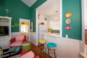 a kitchen with green walls and pink chairs at 46 Davis Love Cottage in Fripp Island