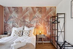a bedroom with a large bed with a tropical wallpaper at NEU! - Urban Green Apartment by Covo Homes in Sindelfingen