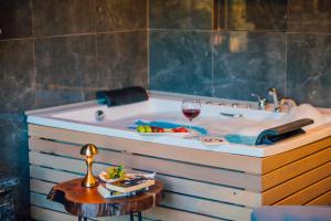 a bath tub with a glass of wine and a table at antik river house in Sile +58 photos