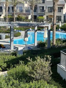 an outdoor swimming pool with umbrellas and a swimming pool at ريفا فيو in El Alamein