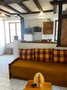 una sala de estar con un sofá y una mesa en La Belle Tuffière, en Montreuil-Bellay