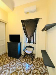 a living room with a tv and a chair at Dimora Barocca in Militello in Val di Catania +3 photos