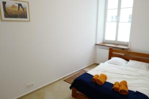 a bedroom with a bed with brown shoes on it at Apartment In the Heart of Warsaw in Warsaw