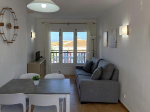 una sala de estar con un sofá y una mesa en Costa Arenal 112 by SOM Menorca, en Arenal d'en Castell
