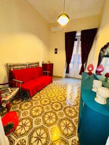 a living room with a red couch and a floor at Dimora Barocca in Militello in Val di Catania