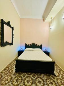 a bedroom with a bed and a mirror on the wall at Dimora Barocca in Militello in Val di Catania