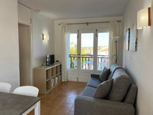 Una sala de estar con un sofá y un balcón. en Costa Arenal 112 by SOM Menorca, en Arenal d'en Castell